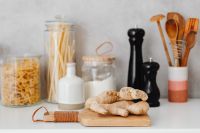 Kaboompics - Pantry Display with Fresh Ginger, Wooden Utensils and Reusable Glass Jars