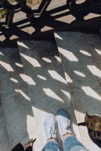 Kaboompics - White Sneakers on Sunlit Marble Steps with Decorative Iron Railing Shadows, Naples Italy Travel Photo