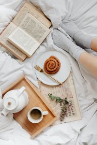 Kaboompics - Gray Lounge Pants beside Coffee and Cinnamon Roll on a White Bed