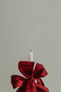 Kaboompics - White Candle with Red Satin Bow and Rising Smoke