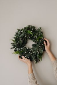 Kaboompics - Woman Arranging Christmas Greenery in Neutral Interior