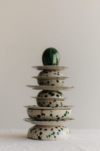 Kaboompics - Green Striped Decoration atop a Stack of Splatter Bowls and Plates