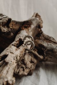 Kaboompics - Interlocking Silver Hoops on Driftwood, Minimal Product Still Life