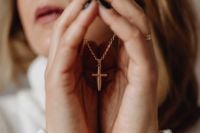 Kaboompics - Woman Holding a Gold Cross Necklace Between Her Hands