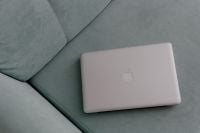 Kaboompics - MacBook laptop lying on mint couch