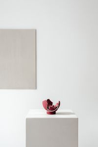 Kaboompics - Broken Red Ceramic Vase on a White Pedestal