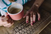 Kaboompics - Woman with wireless wooden keyboard and cup of coffee