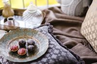 Kaboompics - Balcony Tea Tray with Berry Tarts and Chocolate Truffles on Patterned Cushions