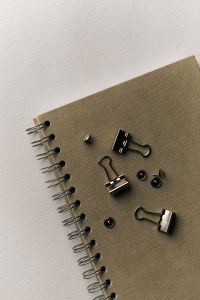 Kaboompics - Notebook with Black Binder Clips and Push Pins