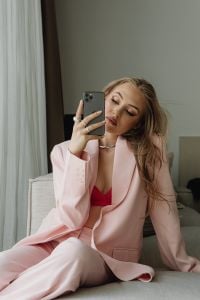 Kaboompics - Woman Holding a Smartphone in a Pale Pink Blazer