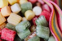 Kaboompics - Close-Up of Sugar-Coated Square Gummies and Rainbow Sour Belt Candy