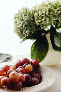Kaboompics - Green Hydrangea Blooms over a Red Grape Plate with Copy Space