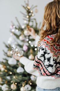 Kaboompics - Woman Hanging Ornaments on a Christmas Tree with Soft Bokeh Lights