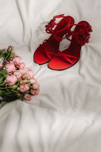 Kaboompics - Red Strappy Heels Beside a Pink Flower Bouquet