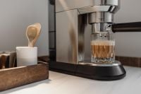 Kaboompics - Layered Coffee Glass Beside Espresso Machine and Coffee Tools
