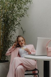 Kaboompics - Woman Drinking Wine Beside a Laptop and Pink Handbag