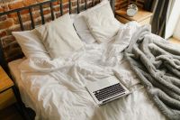 Kaboompics - Laptop on Unmade Bed with Gray Blanket, Work From Home Copy Space