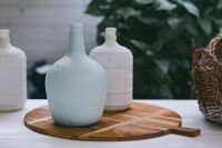 Kaboompics - Pale Blue Glass Bottle and White Jars on a Wooden Board