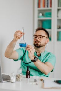 Kaboompics - Doctor Examining Blue Test Liquid in Flask