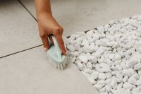 Kaboompics - Hand Brushing White Decorative Stones Beside Floor Tiles