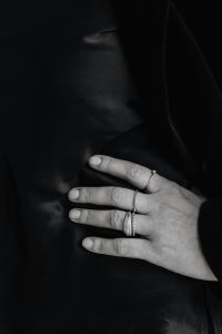 Kaboompics - Black and White Hand Resting on Black Blazer with Rings