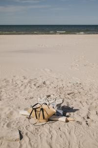 Kaboompics - Beach Setup with Straw Bag and Folded Textiles by the Sea