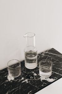 Kaboompics - Top View of Glass Carafe and Two Water Glasses on Black Marble