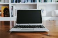 Kaboompics - Silver Laptop Facing Forward on a Wooden Desk with Bookshelves