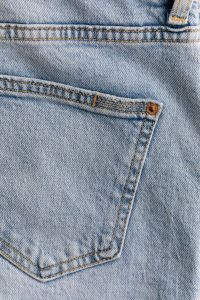 Kaboompics - Vertical Close-Up of Light Blue Jeans Back Pocket, Copper Rivet and Double Stitching