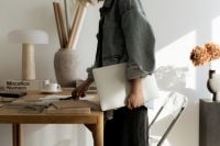 Kaboompics - Interior Designer Carrying Laptop through a Sunlit Creative Studio