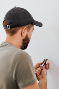 Kaboompics - Handyman Working on a Small Wall Fixture with Hand Tools, Home Repair Close-Up