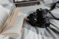 Kaboompics - A camera, MacBook, and a book waiting in bed