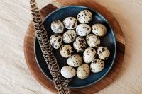 Speckled Eggs and a Patterned Feather on a Navy Plate, Rustic Easter Food Styling