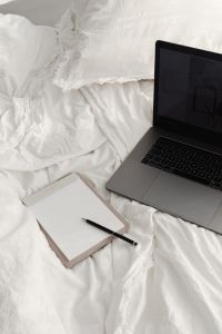 Kaboompics - Remote Work Essentials: Notebook and Laptop on a White Bed