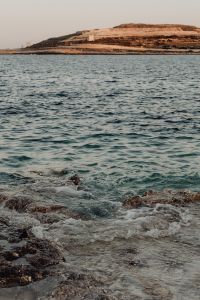 Kaboompics - Rocky Shoreline with Distant Coastal Hills Across the Sea