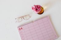 Kaboompics - Pink Monthly Planner with Carnation Vase and Glasses for Productivity Content