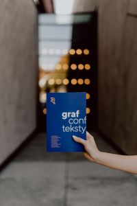The woman is holding books in her hands