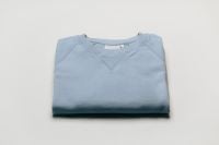 Kaboompics - Folded Blue Sweatshirt on a White Background