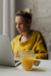 Kaboompics - Soft Focus Remote Work Portrait with Laptop and Orange Juice in Foreground