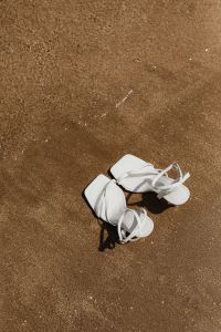 Kaboompics - White Strappy Sandals Laid on Wet Beach Sand