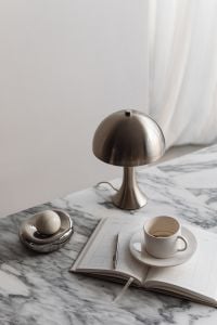 Kaboompics - Chrome Dome Lamp, Coffee Cup and Open Planner on Arabescato Marble
