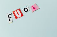 Kaboompics - Colorful Cutout Letters Spelling “Fuck” in a Horizontal Row, Bold Graphic Design Background