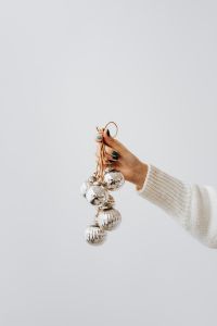 Kaboompics - Minimal White Background with Silver Baubles Held in One Hand