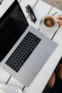 Kaboompics - Laptop, Reading Glasses and Coffee on a White Table