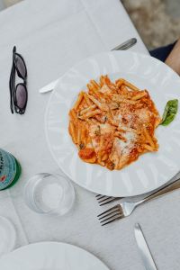 Kaboompics - Overhead Tomato Pasta with Sunglasses, Cutlery and Water Glass