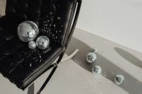 Kaboompics - Black Leather Chair with Disco Balls, Metallic Ribbons and Deep Shadows