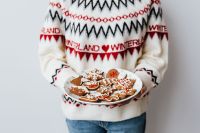 Kaboompics - Woman in a white Christmas sweater holds gingerbread cookies on plate
