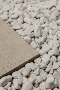 Kaboompics - White Pebbles Beside a Diagonal Beige Stone Slab, Textured Background