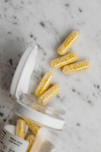 Kaboompics - Bead-Filled Capsules Spilling from an Open Bottle