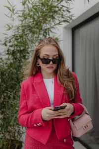 Kaboompics - Woman Checking a Smartphone in a Fuchsia Blazer